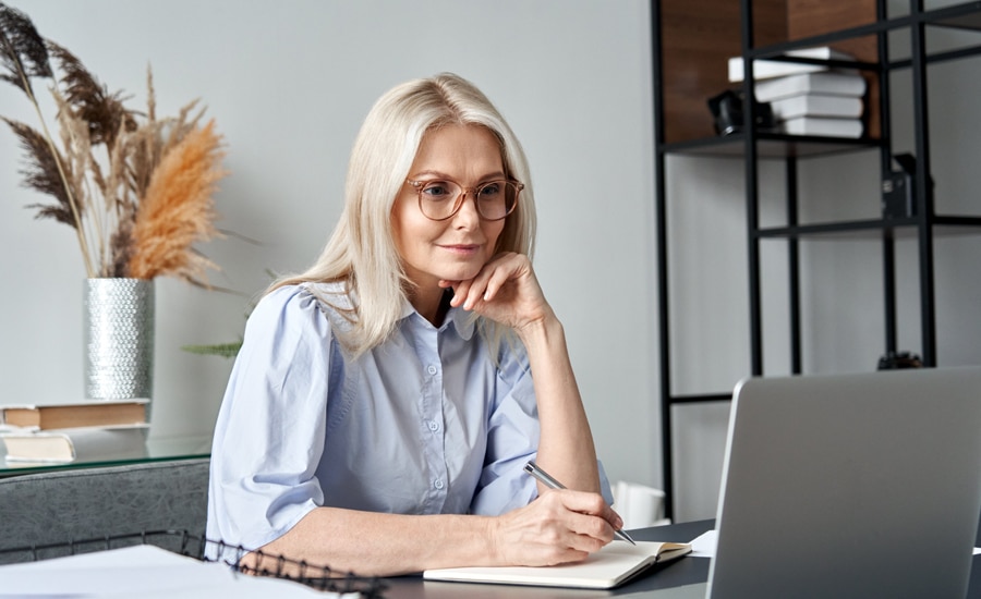 Mujer revisa en su laptop la resolución de la facturación electrónica